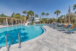 Une piscine équipée de chaises longues et d’un toboggan aquatique.