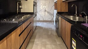 A modern kitchen with a central island, built-in oven, and stainless steel appliances. - Cosy Nile view Rowers 3 bedroom condo (Giza Governorate)