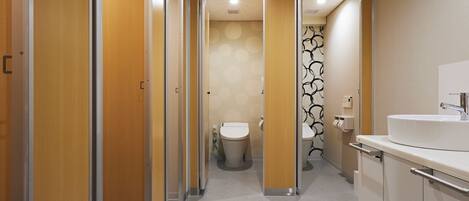Un baño moderno con inodoro, lavabo y ducha.