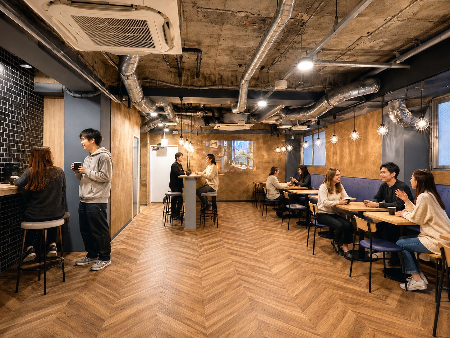 Un café con suelo de madera, conductos expuestos e iluminación colgante.