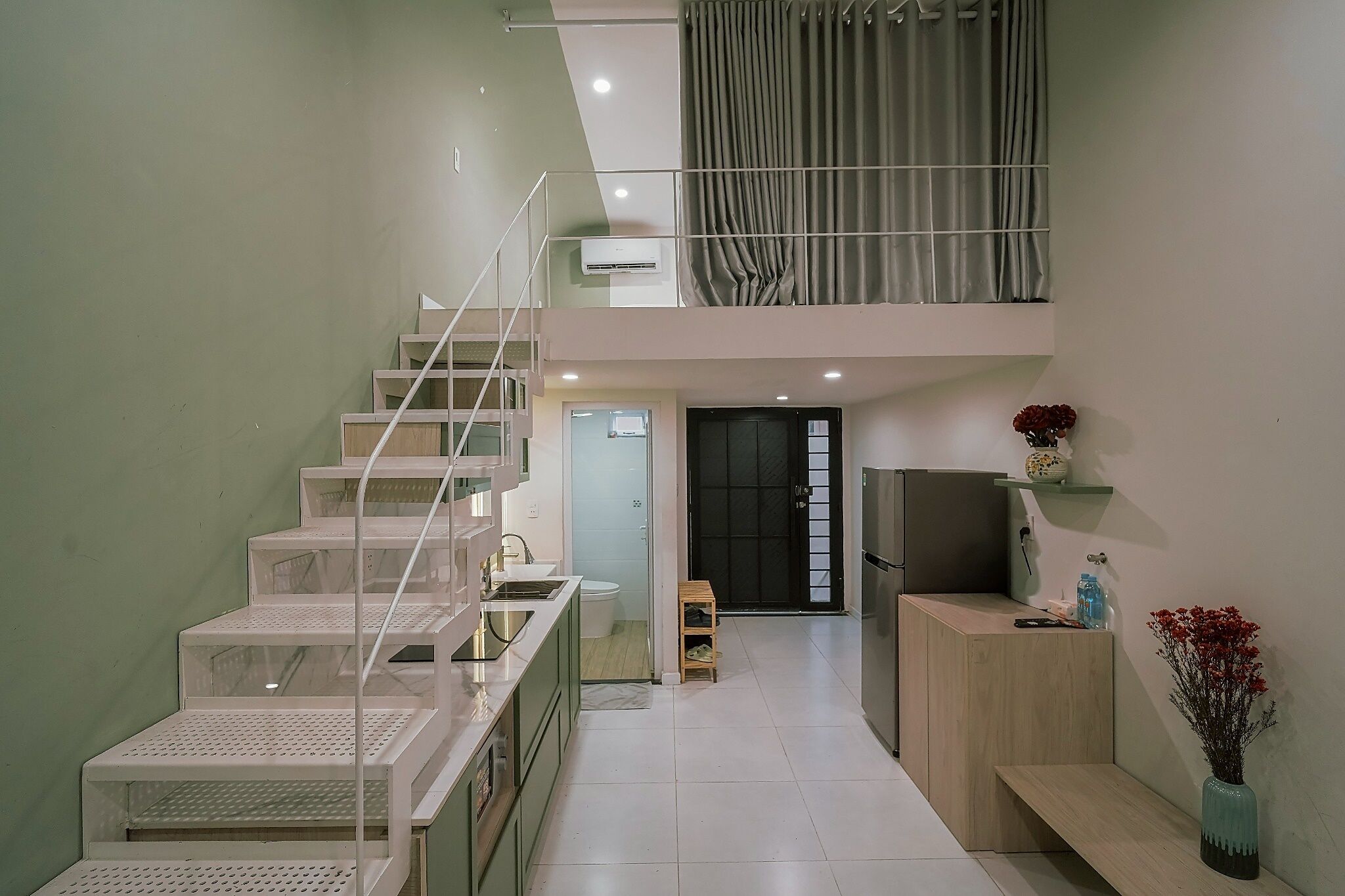 Ein modernes Interieur mit Treppe, Küchenbereich und Wohnraum.