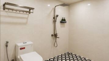 A bathroom with a toilet, a shower, and a sink.