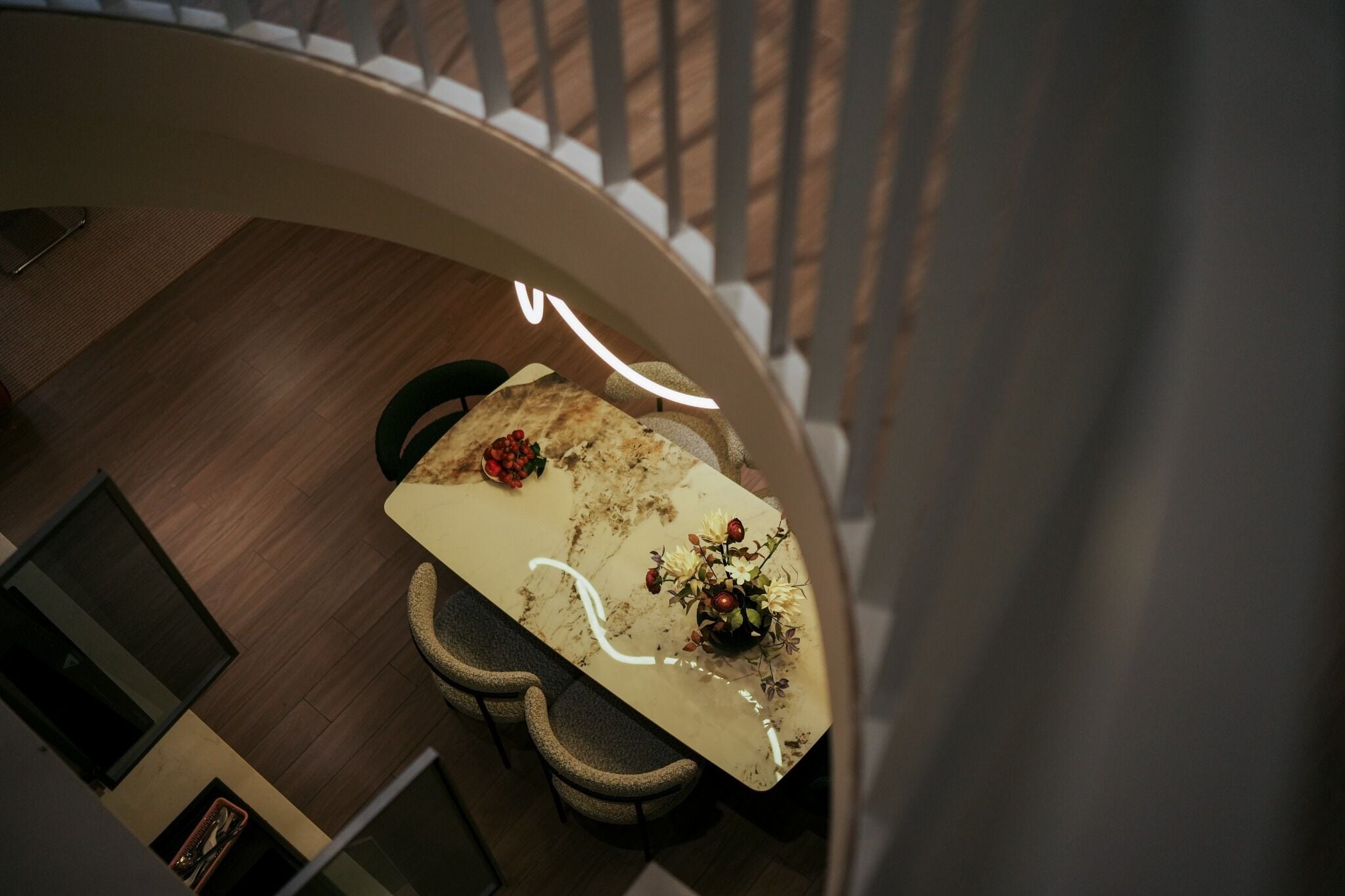 Un coin repas avec une table en marbre, des chaises et un vase de fleurs.