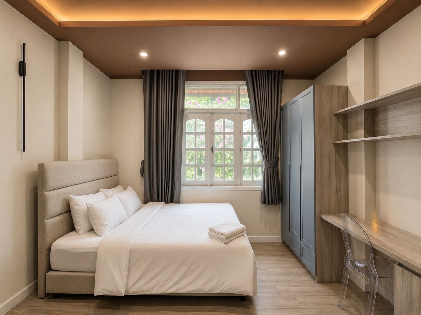 A bedroom with a bed, curtains, a window, a wardrobe, and a desk.
