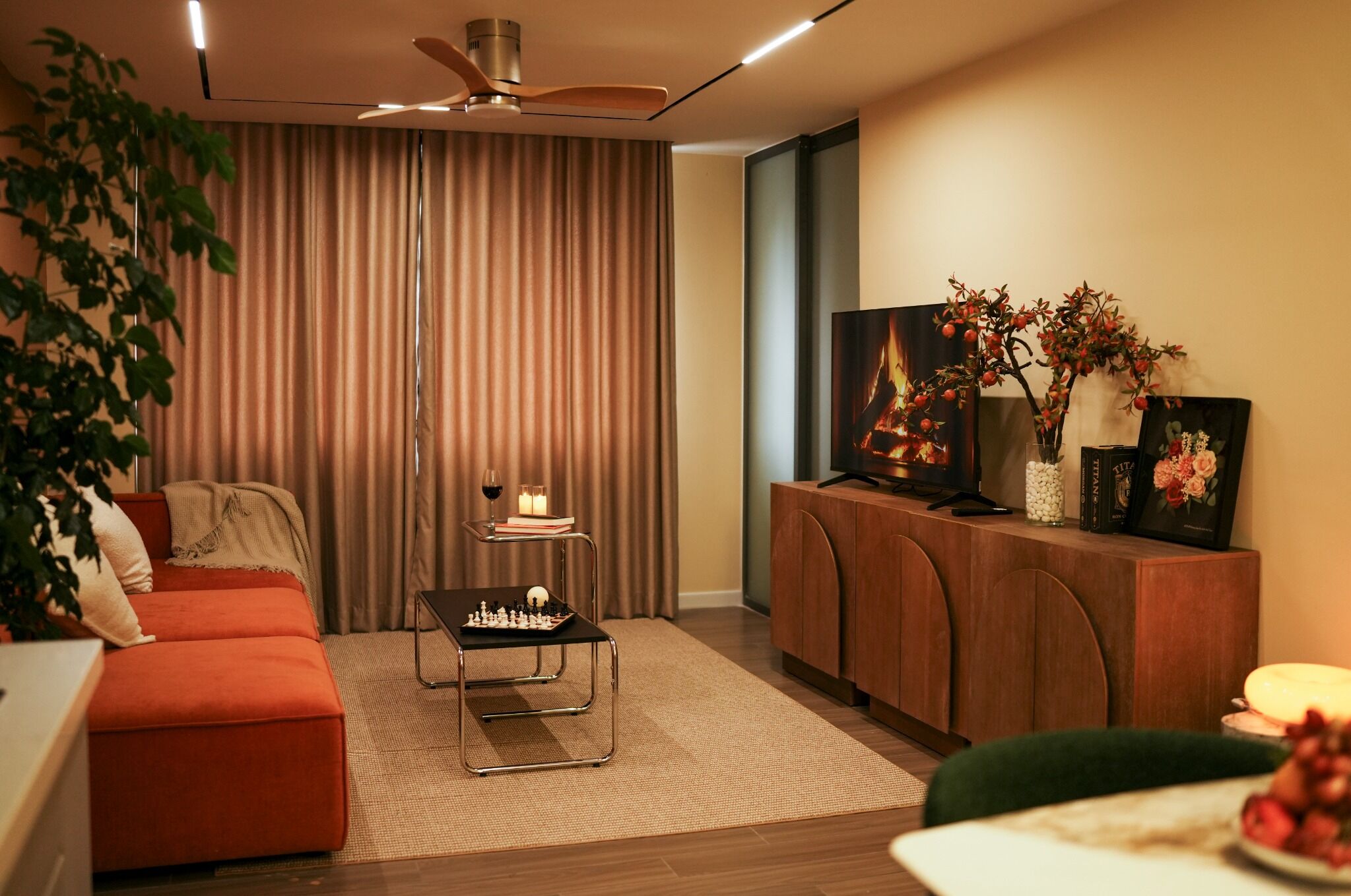 A modern living room with a sofa, a coffee table, a TV, and a bookshelf.