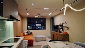 Una cocina moderna con comedor, sofá y vistas a la ciudad de noche.