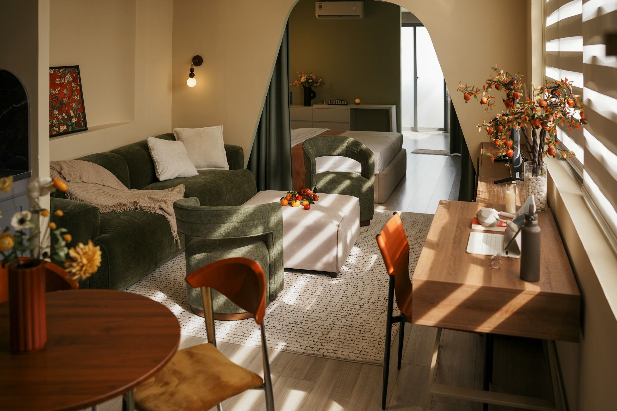 A cozy living area with a sofa, chairs, a dining table, and a small kitchen area.