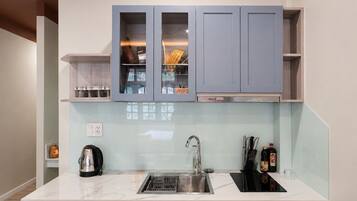 A modern kitchen with a built-in dishwasher, a sink, and cabinets with glass doors.