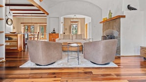 A spacious living room with a high ceiling, wooden beams, a fireplace, and a cozy seating area. - Elegant Cobb House w/ Spa | Pond | Chef Kitchen (Kenwood)