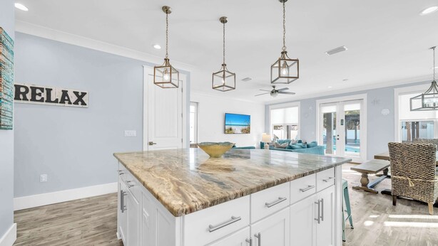 A modern kitchen with a marble countertop, white cabinets, and pendant lights. - Shore Thing Getaway | 1 PM Check in! | Large Private Pool & Pergola! | One Block to the New Tarpon Beach Park! | Crystal Beach Gem, Sleeps 22 (Destin)