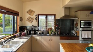 Una cocina moderna con un amplio ventanal, electrodomésticos integrados y encimera de madera.