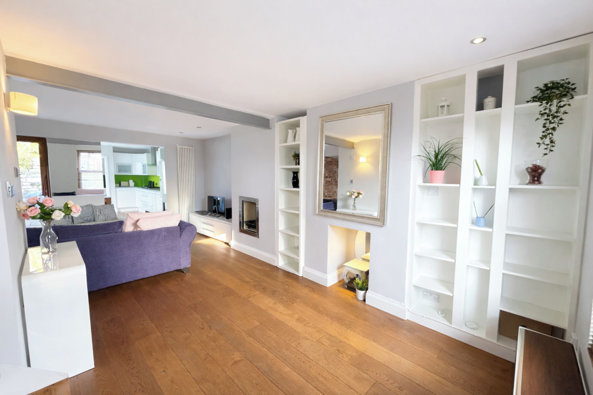 A modern living room with a sofa, a fireplace, and built-in shelving.