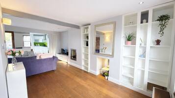 A modern living room with a sofa, a fireplace, and built-in shelving.