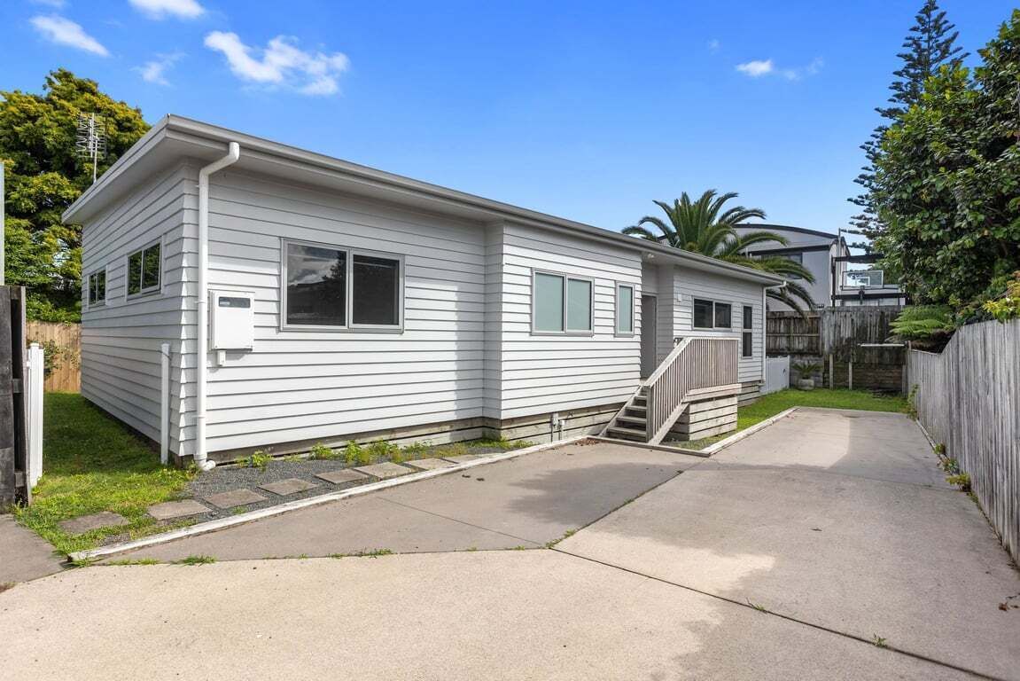 Une maison mobile de plain-pied, dotée d’un porche à l’avant et d’un petit escalier menant à l’entrée.