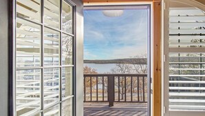 A view from a balcony with a wooden deck and metal railings, overlooking a body of water and trees. - Emerald Point, Lakefront with Gorgeous Views! (McAlester)