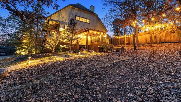 A house with a covered porch, a garage, and a yard with string lights. - Emerald Point, Lakefront with Gorgeous Views! (McAlester)