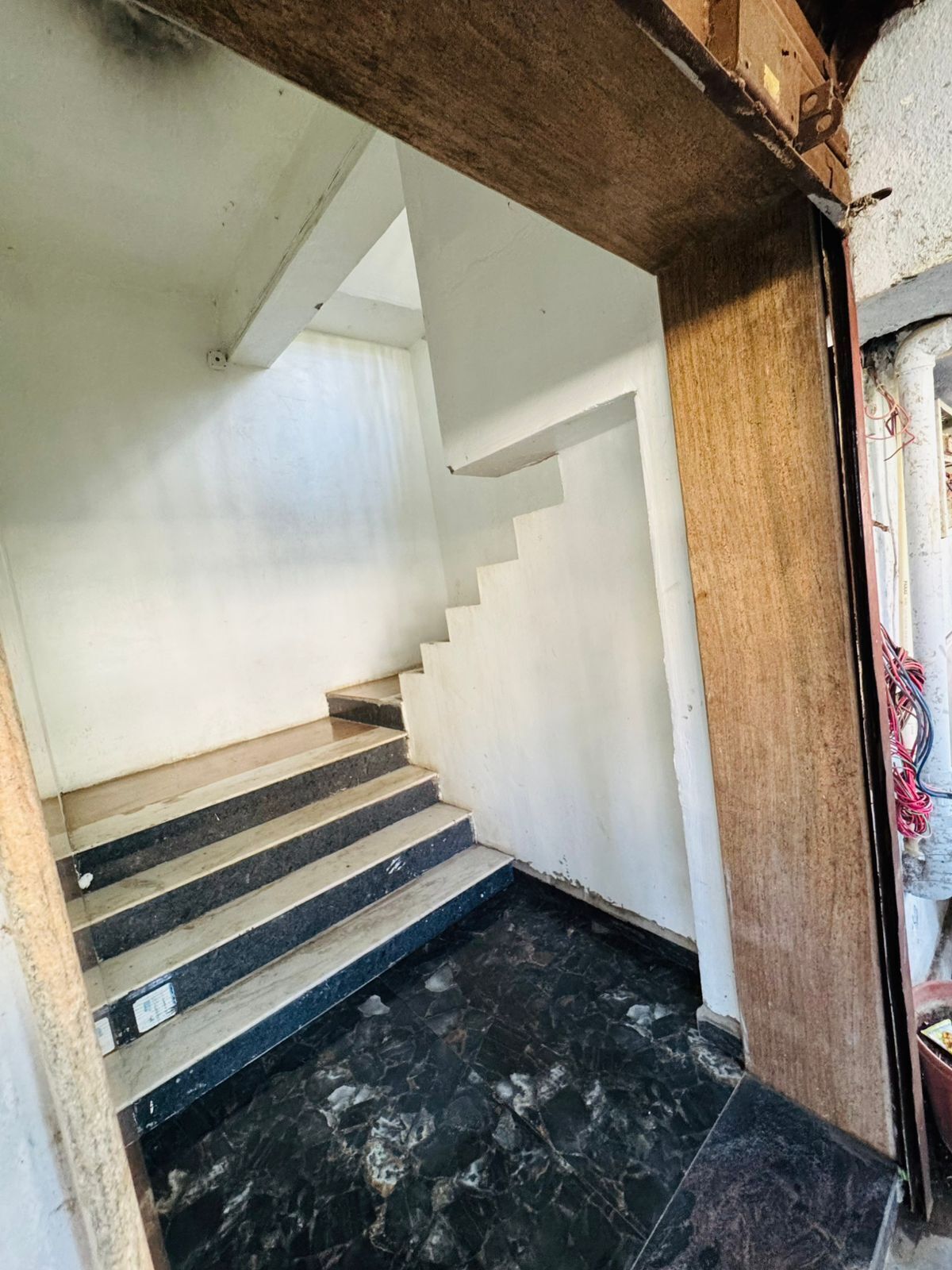 A staircase with a dark marble floor leading to a higher level.