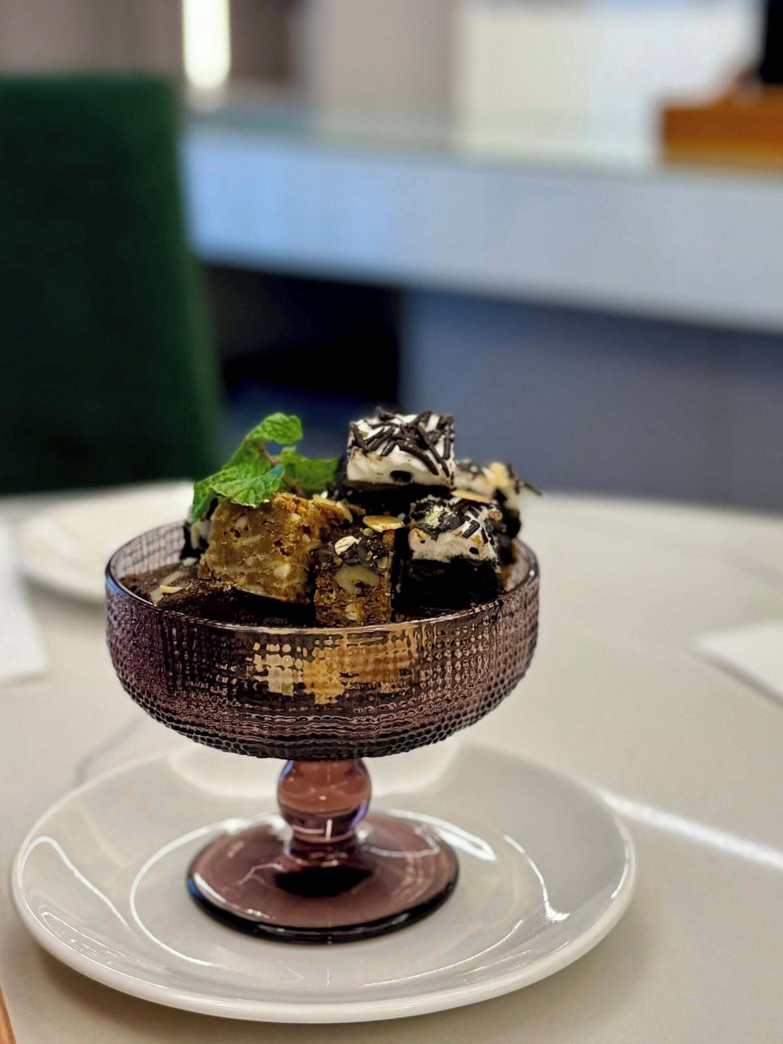Un dessert servi dans un bol décoratif sur une assiette blanche.
