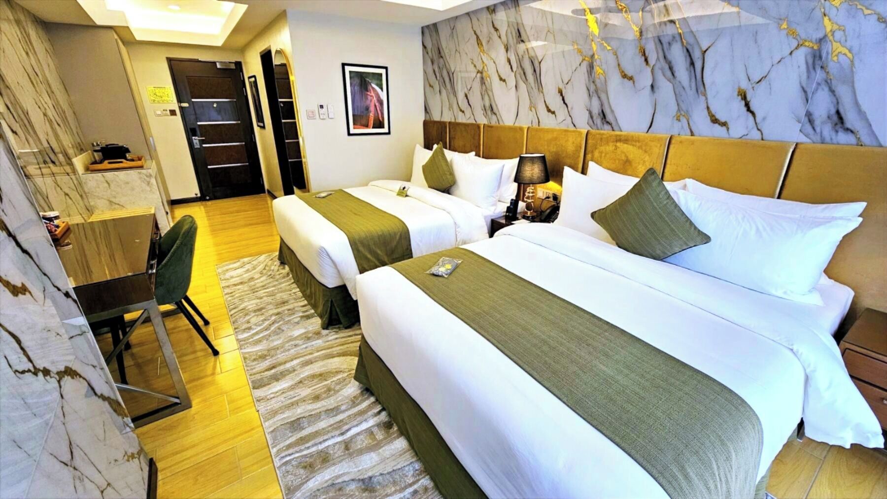 Een hotelkamer met twee bedden, een bureau en een stoel.