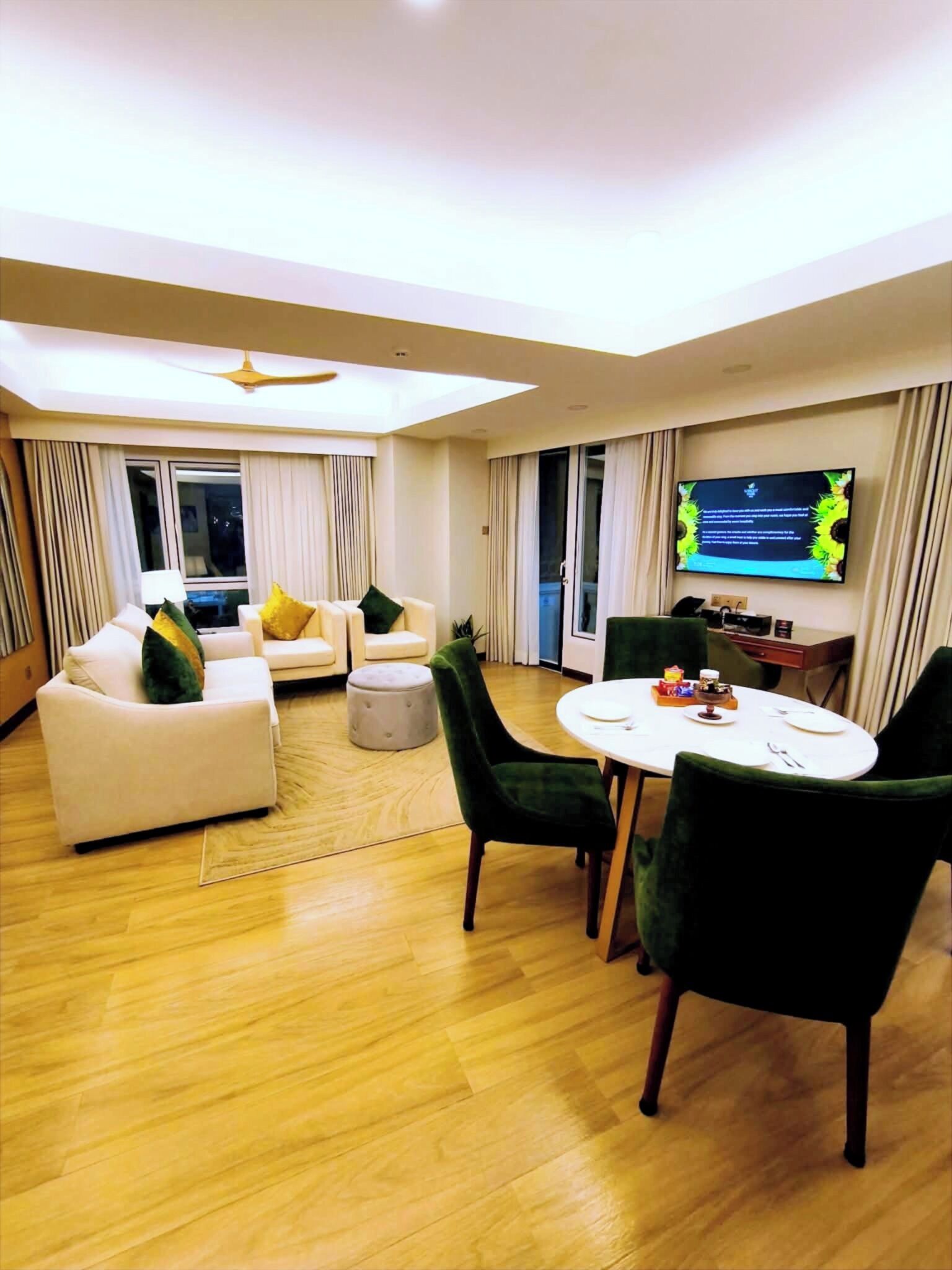 A modern living room with a sofa, ottoman, and dining table with chairs.