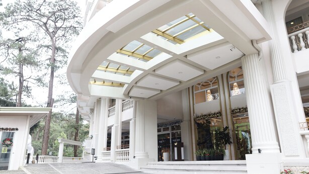 A grand hotel entrance with a covered walkway, large windows, and a well-maintained exterior. - Wright Park Hotel (Baguio)