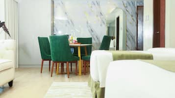Een hotelkamer met een bed, een eettafel met stoelen, een spiegel en een kledingkast.