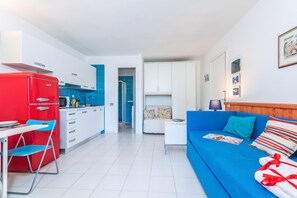 A compact living space with a kitchenette, a dining area, and a sofa. - Vacanze Da Giuly With Shared Pool (Olbia)
