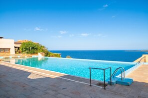 A clear blue sky, a swimming pool with a view of the sea, and a building with a tiled roof. - Vacanze Da Giuly With Shared Pool (Olbia)