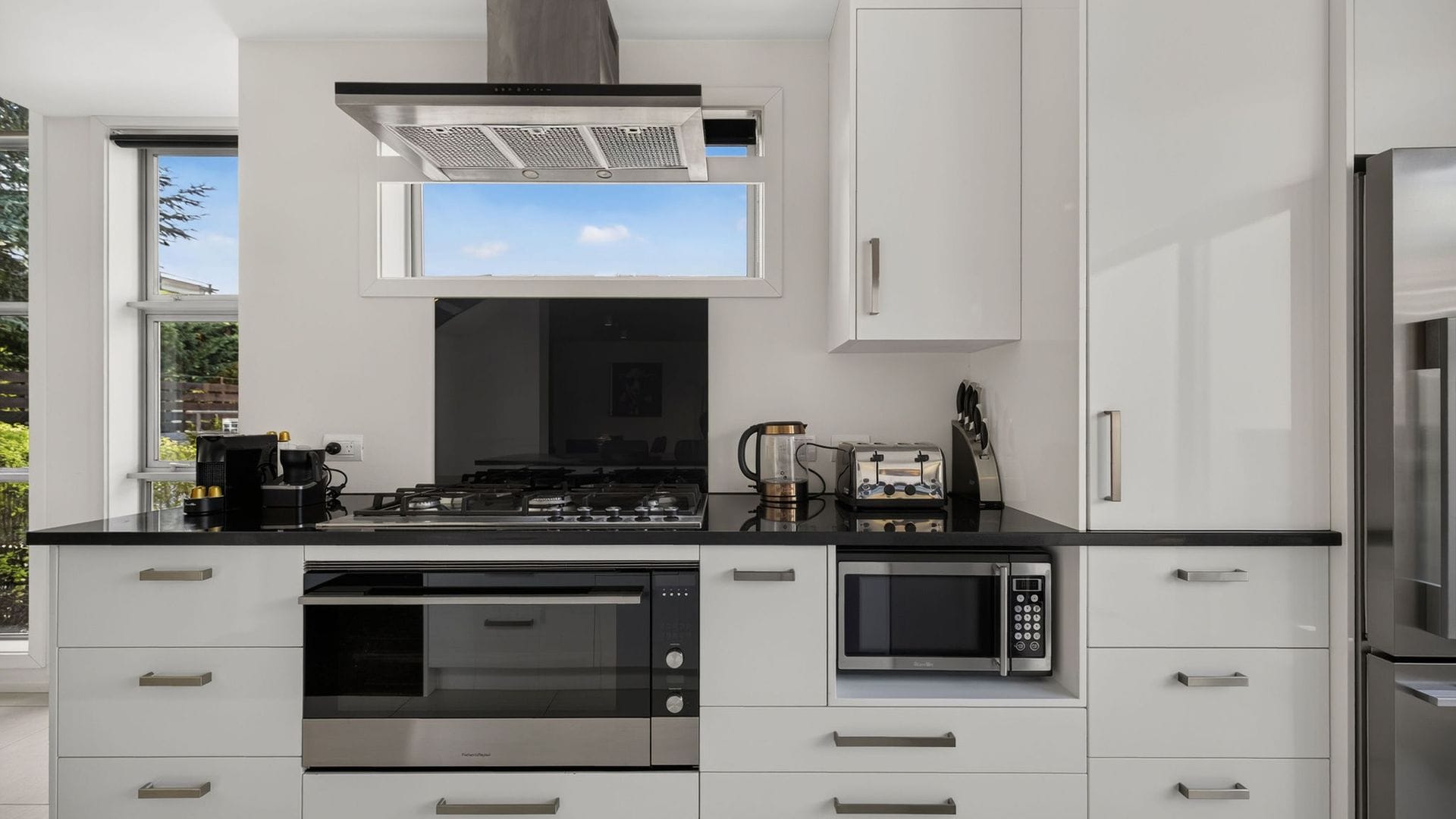 A modern kitchen with a gas stove, microwave, and built-in oven.