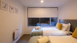 A hotel room with two beds, a large window, and a radiator. - Apartment G3 3BR Near Queenstown Centre (Queenstown)