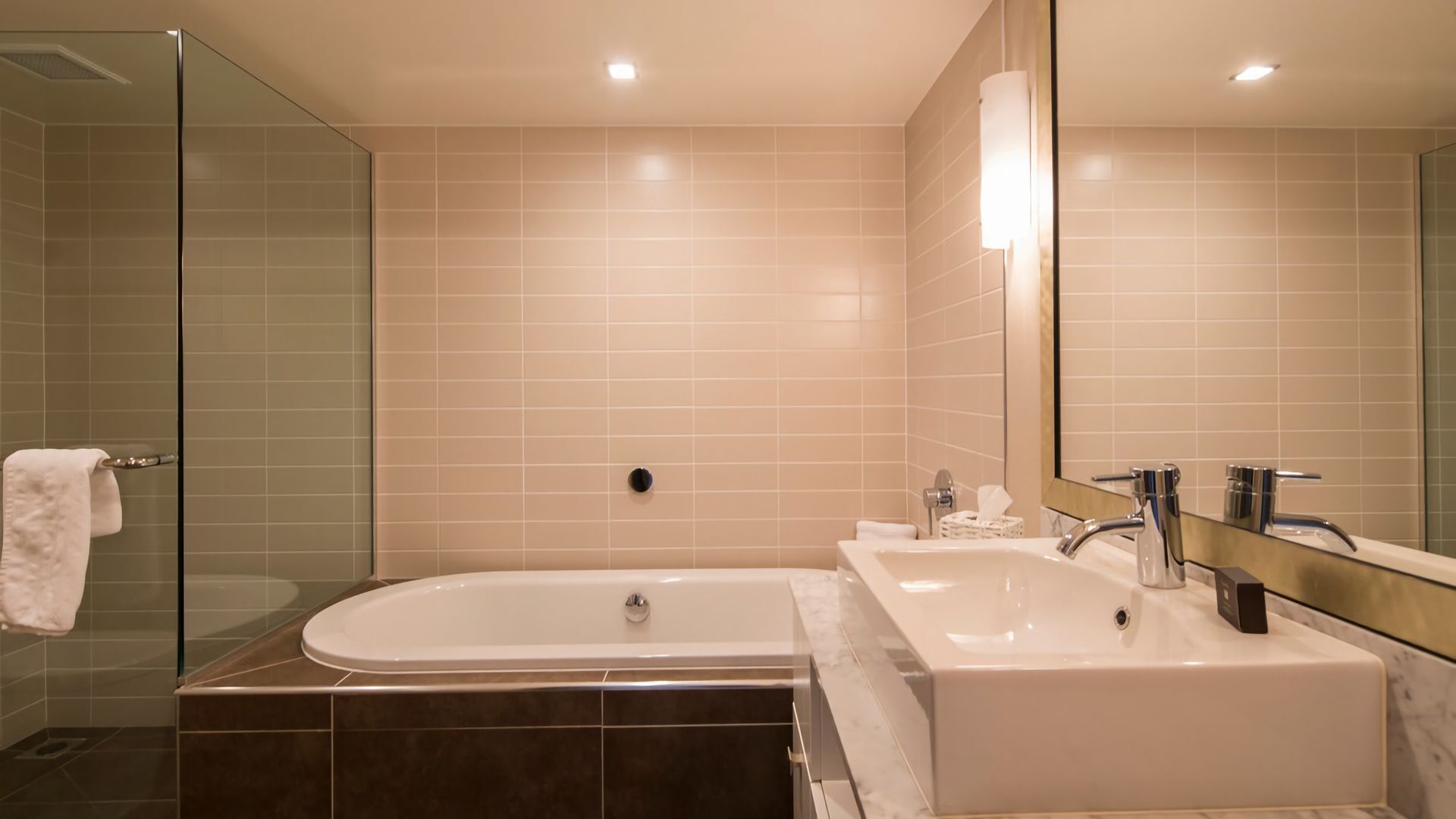 Une salle de bain moderne dotée d’une douche à parois de verre, d’une baignoire sur pieds et d’un meuble-lavabo avec un miroir.