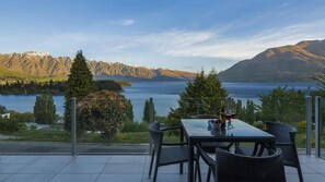 A terrace with a table and chairs overlooking a lake and mountains. - LakeRidge Queenstown Front Row (Queenstown)