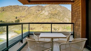 Un balcone con tavolo e sedie, con vista su un paesaggio montano.