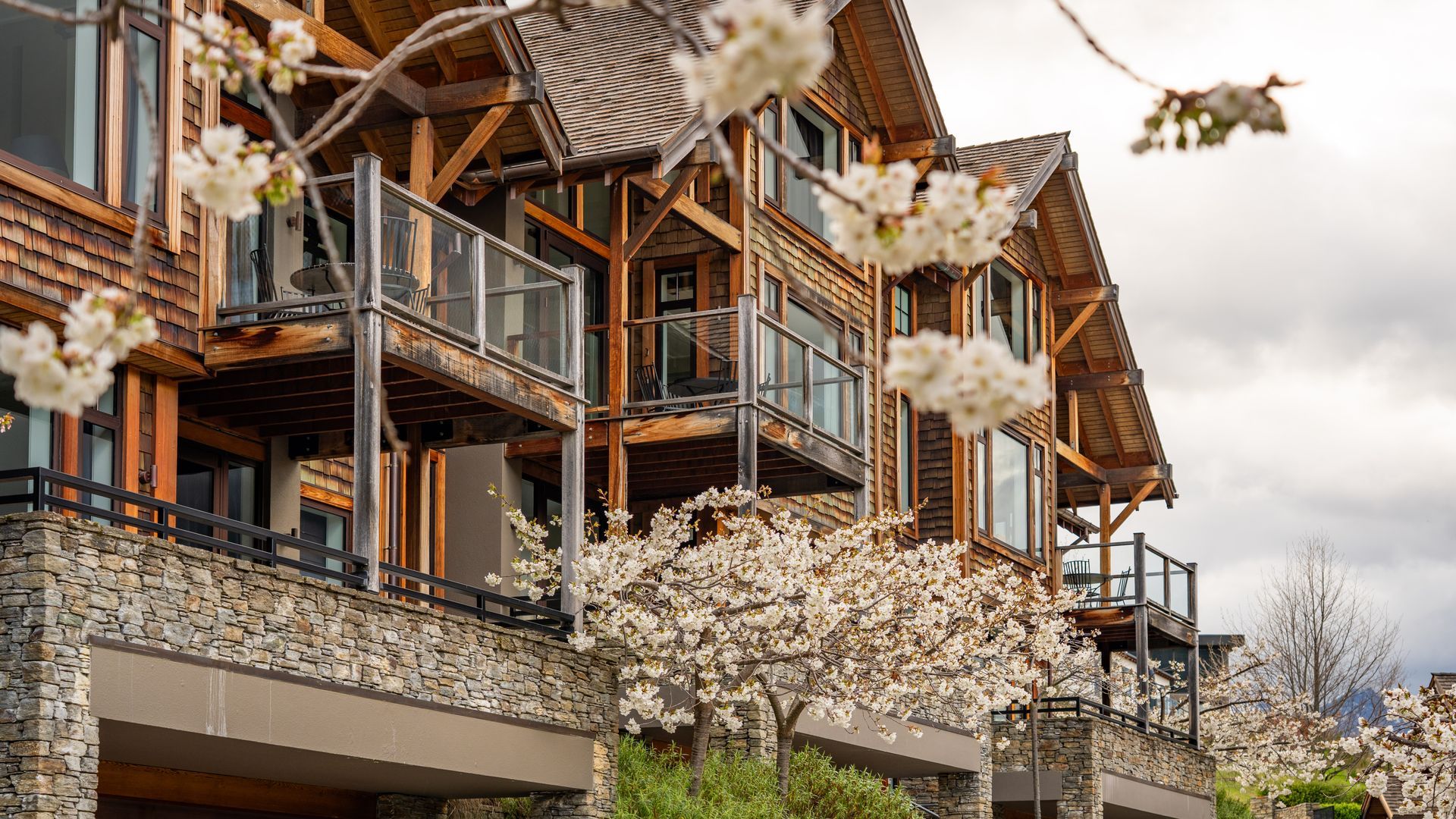 A multi-story wooden building with balconies and large windows.