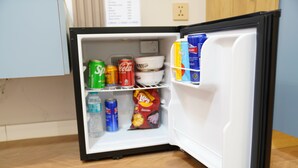 An open mini-fridge containing various beverages and snacks. - Misoko hotel (Ulaanbaatar)