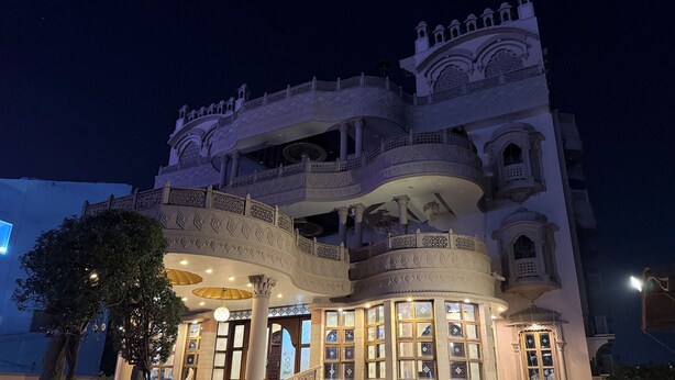 A multi-story building with ornate balconies and a grand entrance. - Virasat Haveli (Varanasi)
