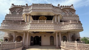 A grand building with intricate architectural details, multiple balconies, and a spacious entrance area. - Virasat Haveli (Varanasi)