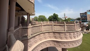A balcony with ornate carvings and a view of the cityscape. - Virasat Haveli (Varanasi)