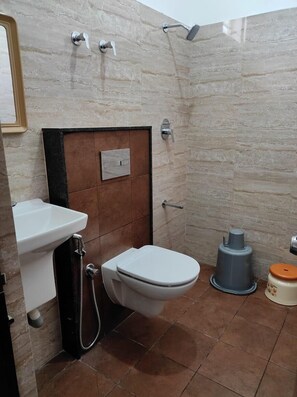 A bathroom with a toilet, sink, and shower. - Hotel Royal Suites (Bengaluru)