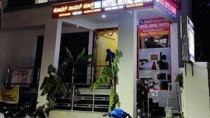 A hotel with a sign for "HOTEL ROYAL SUITES" and "DELUXE ROOMS". - Hotel Royal Suites (Bengaluru)