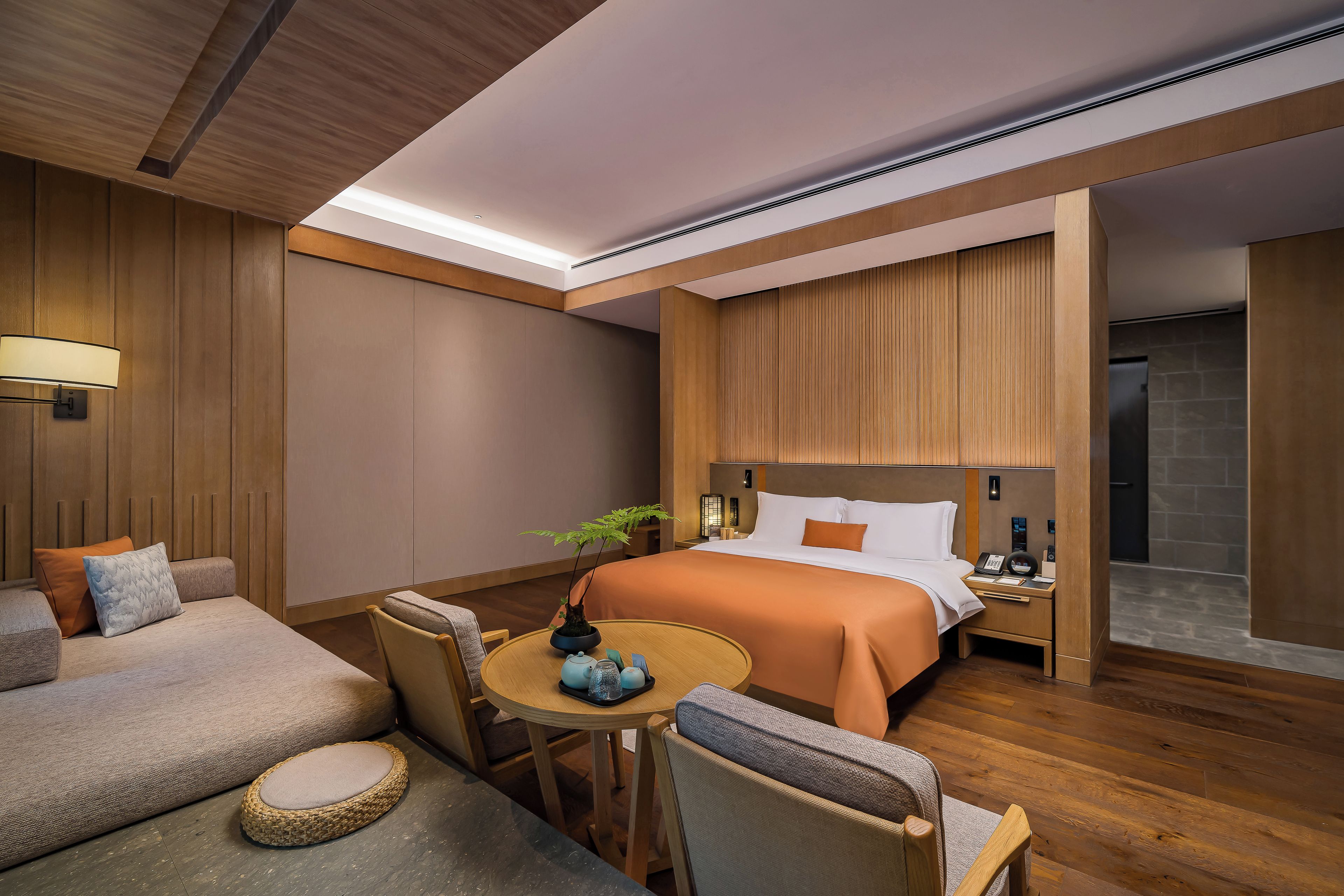 Una habitación de hotel con una cama, un escritorio, una silla, una mesita y un sofá.