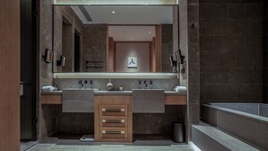 Un baño moderno con dos lavamanos, un espejo y cabina de ducha.