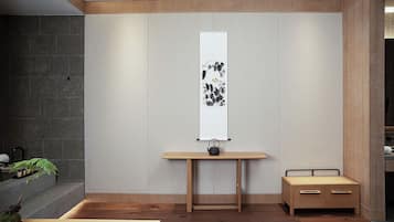 Una habitación minimalista con un escritorio de madera, una cama, una obra de arte en la pared y una planta en maceta.