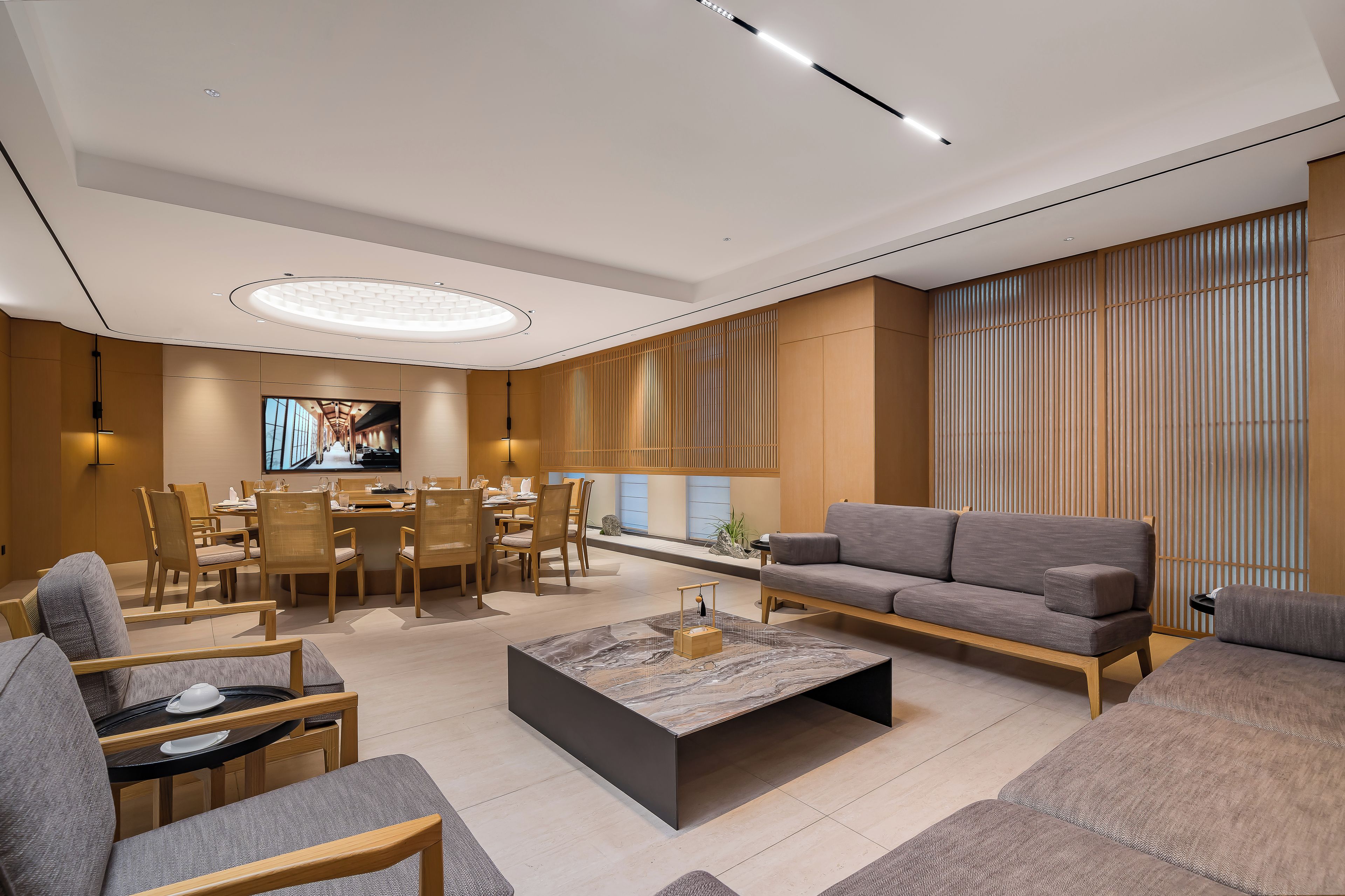 A modern living room with a sofa, dining table, and chairs.