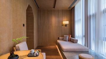 Un interior moderno con una pared de madera, un sofá, una mesa redonda con una planta y una lámpara.