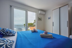 A bedroom with a bed, a window, and a view of the sea. - Valdarke Vittorio Apt With Sea View Terrace (Mali Losinj)