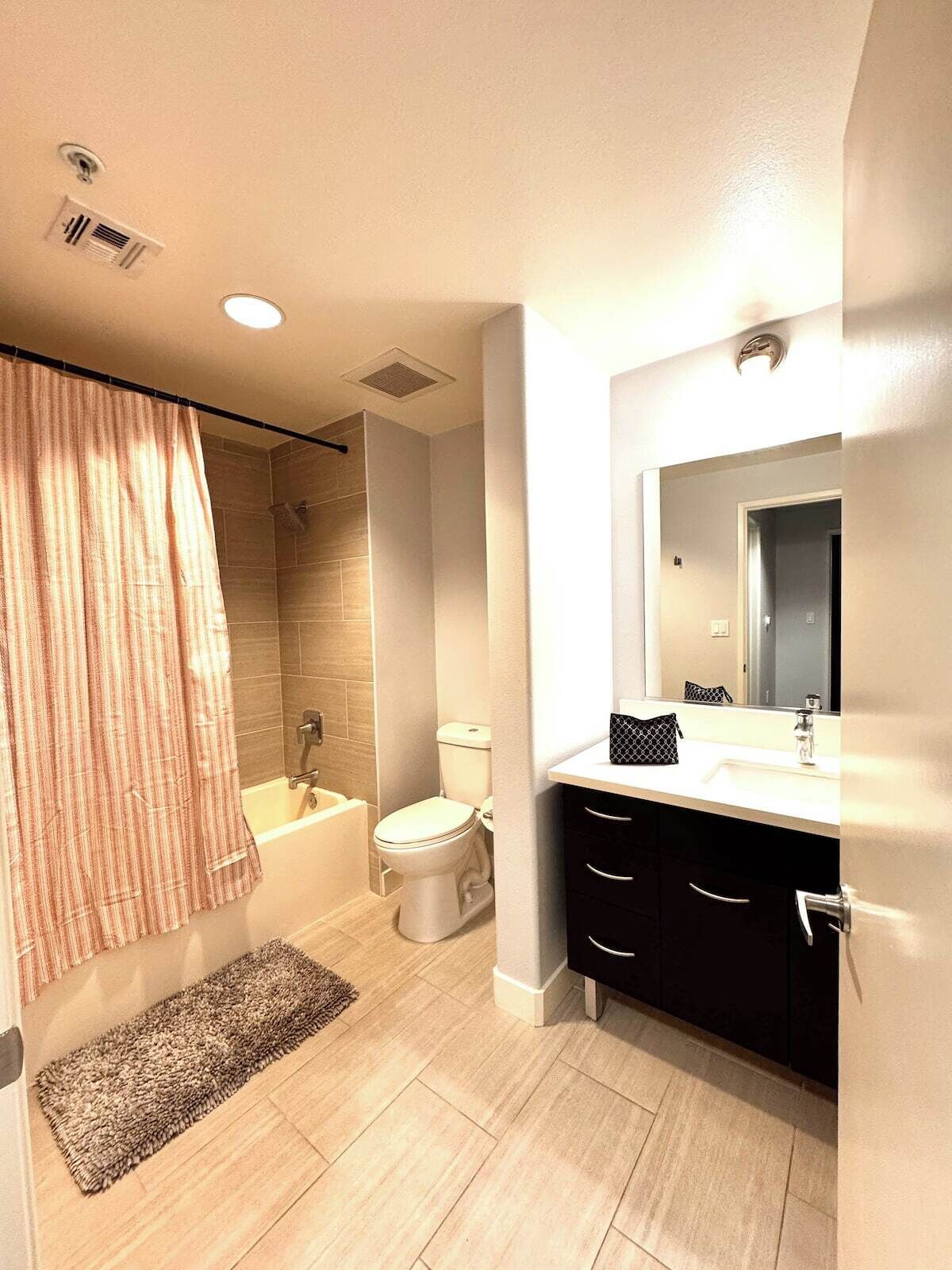A modern bathroom with a shower, toilet, and sink.