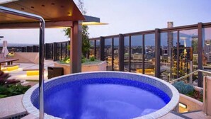 Una piscina en la azotea con vistas despejadas del horizonte urbano.
