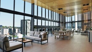 Un interior espacioso y moderno con ventanas amplias, un comedor y una zona de estar con sofás y mesas.