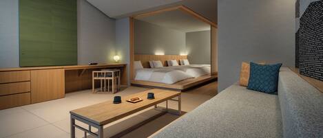 Una habitación de hotel moderna con cama, escritorio, sofá y mesa de comedor.